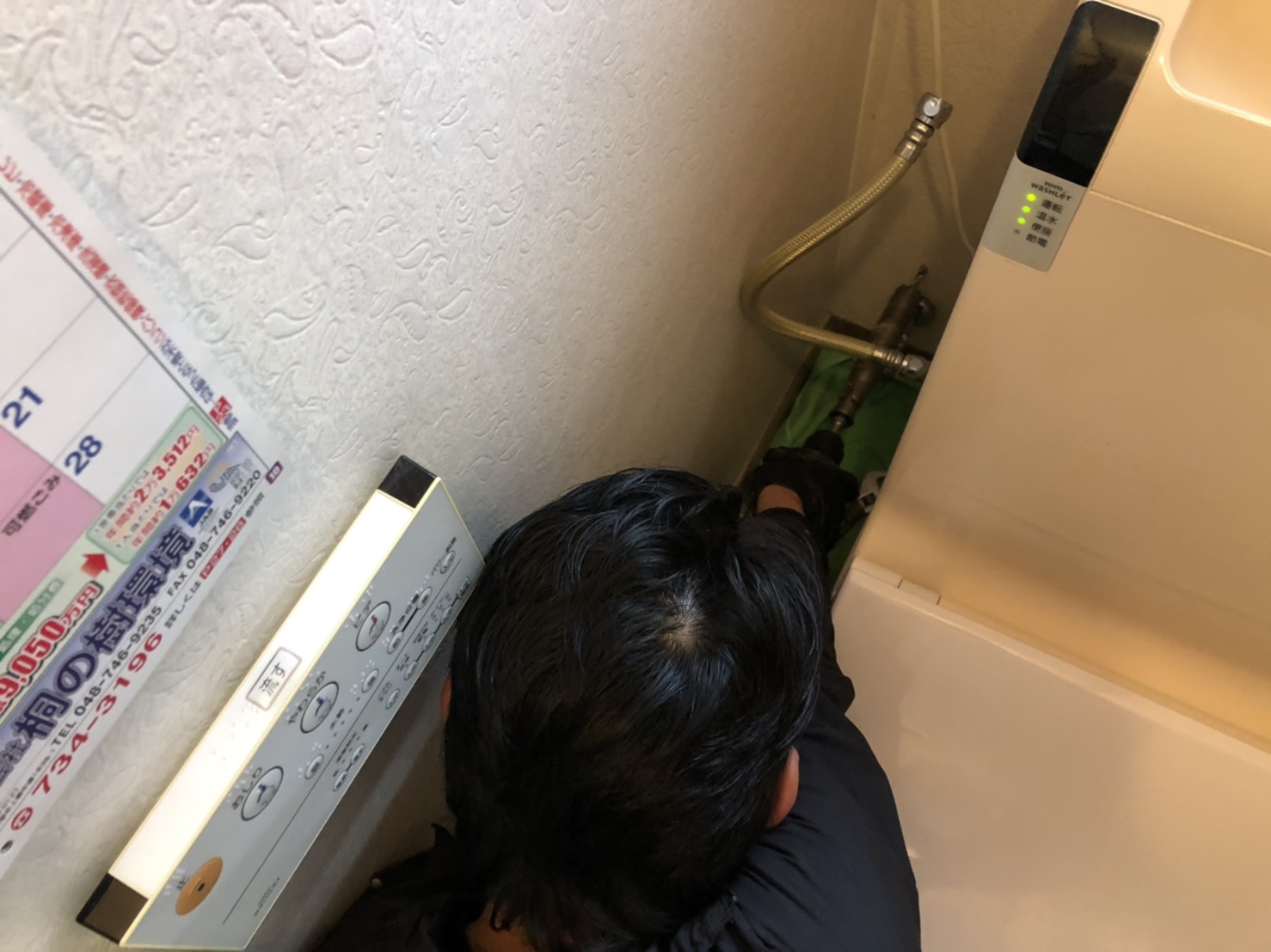 新設給水管を屋内へ引き込むための壁面穴開け作業中